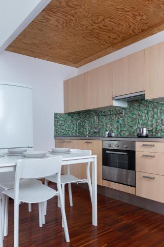 a kitchen with a white table and white chairs at White and Brown Exclusive Loft With Terrace - Free Parking - M2 station in Milan