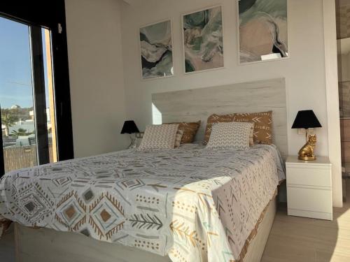 a bedroom with a large bed and a large window at Villa Finestrat Benidorm Golf y Playa in Cala de Finestrat