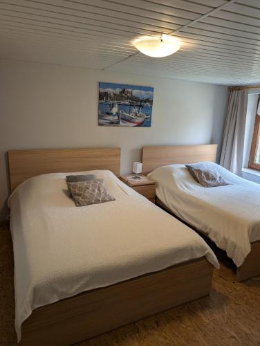 - une chambre avec 2 lits et une lampe sur le mur dans l'établissement Gîte du Coucou, à Hargnies