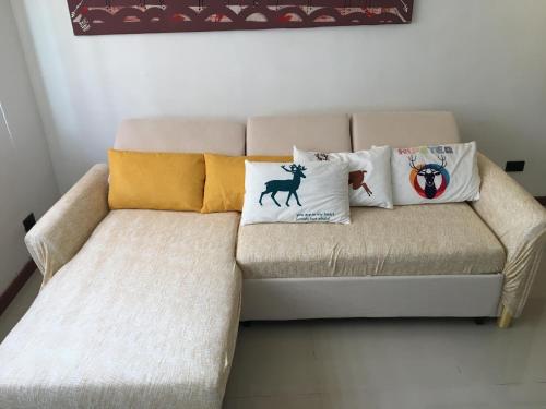 a couch with pillows on it in a room at Stay in Manila, Cambridge Village in Cainta