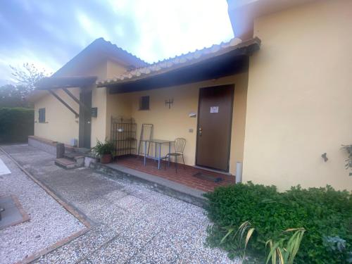 a house with a porch with a table and chairs at Agriturismo il fragolino in Bassano Romano