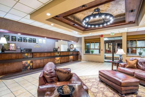 a lobby with leather furniture and a bar at Clarion Inn Grand Junction Airport in Grand Junction