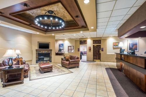 a lobby with a living room with couches and a fireplace at Clarion Inn Grand Junction Airport in Grand Junction