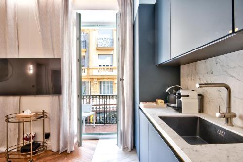 a kitchen with a sink and a large window at Aparthotel 9 ALBERTI Nice Centre in Nice
