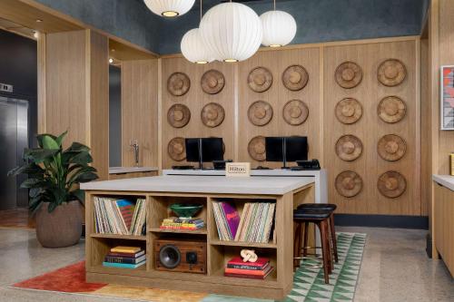 a lobby with a island with a book shelf at Motto By Hilton Bentonville Downtown in Bentonville