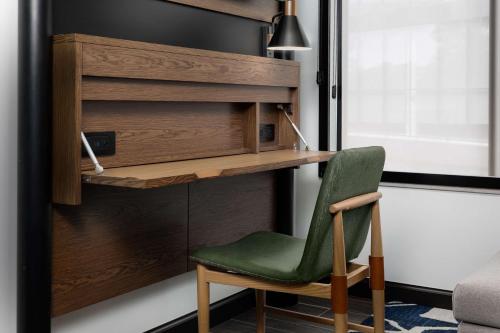 a green chair in front of a desk at Motto By Hilton Bentonville Downtown in Bentonville