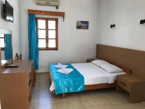 a bedroom with a bed and a desk and a window at Ali Baba Hotel Gümbet in Gümbet