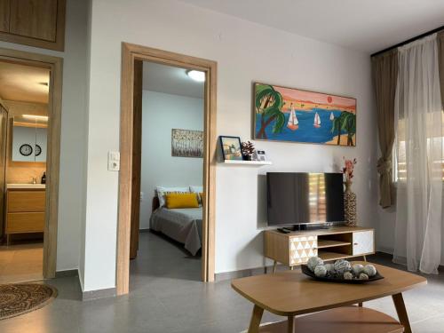 un salon avec un canapé et une télévision dans l'établissement New & comfy apt near Heraklion-airport and sea, à Néa Alikarnassós
