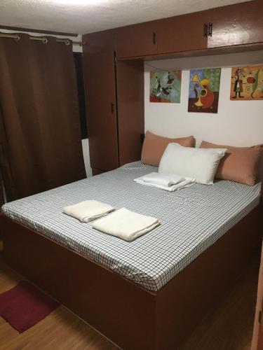 a bed in a room with two towels on it at Stay in Manila, Cambridge Village in Cainta