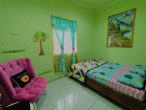 a bedroom with a bed and a pair of chairs at D-Rima Homestay Ruteng in Ruteng