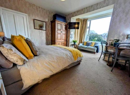 a bedroom with a large bed with yellow pillows at Super sunny studio with own terrace & parking in Poole