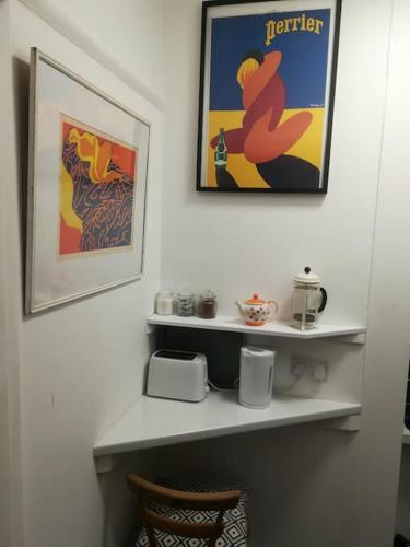 a room with a shelf and a picture on the wall at Super sunny studio with own terrace & parking in Poole
