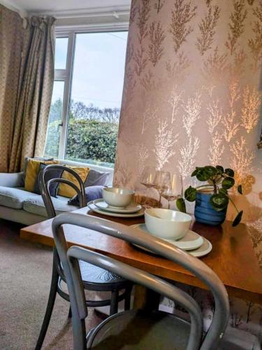 a dining room table with bowls and plates on it at Super sunny studio with own terrace & parking in Poole