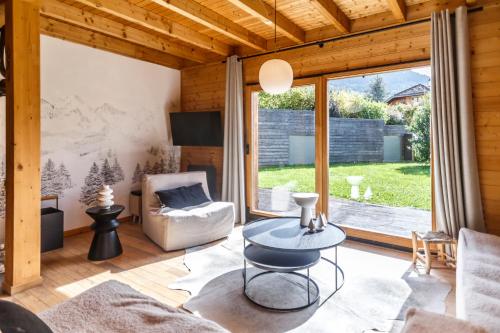 a living room with a table and a large window at Chalet Ilca in Thollon