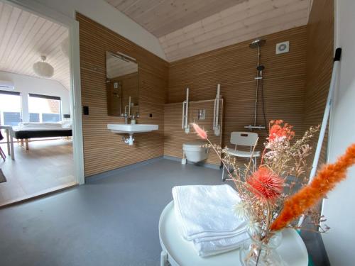 NymindegabにあるEsehytter Luxury Holiday Home near Beachのバスルーム(シンク、テーブル付)が備わる客室です。