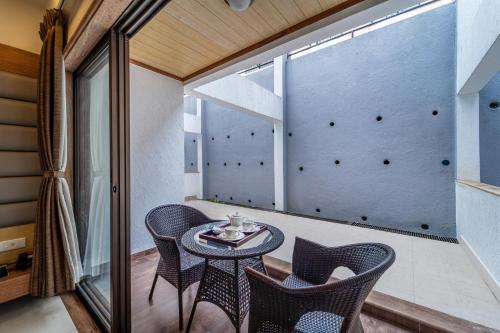 a room with a table and chairs on a balcony at Sterling Panchgani in Panchgani