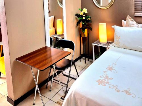 a room with a bed and a table and chairs at URlyfstyle Cottage 10km from OR Tambo Int Airport in Kempton Park
