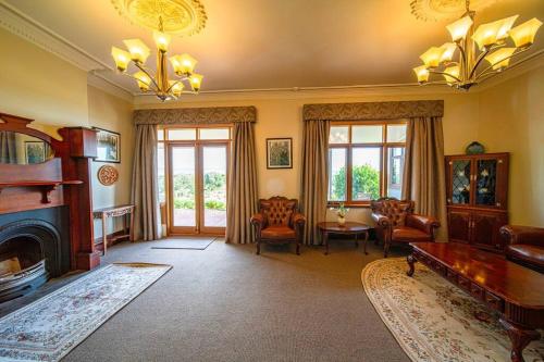 a living room with a fireplace and a table and chairs at Condor Estate Spacious with Vineyard & Fireplace in Maslin Beach