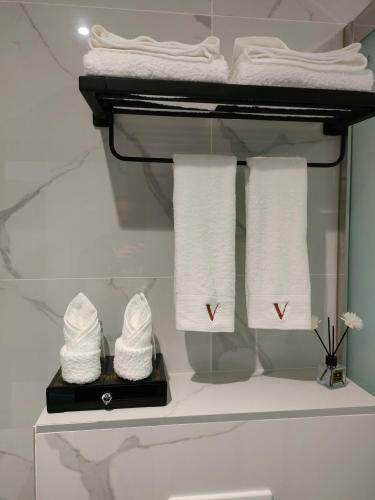 - un ensemble de serviettes sur un portant dans la salle de bains dans l'établissement Hôtel Restaurant La Paillote, à Cavignac