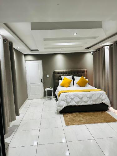een slaapkamer met een bed met gele kussens erop bij West Home Rest in Westonaria