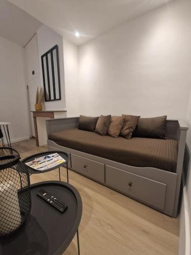 - un lit dans un salon avec un canapé dans l'établissement La petite parenthèse au centre ville, à Chalon-sur-Saône