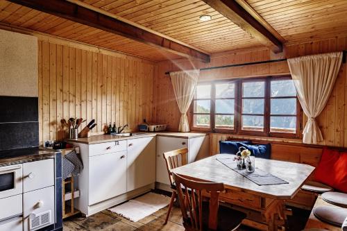 a kitchen with a table and chairs in a room at Flasswiesen Alm in Lienz