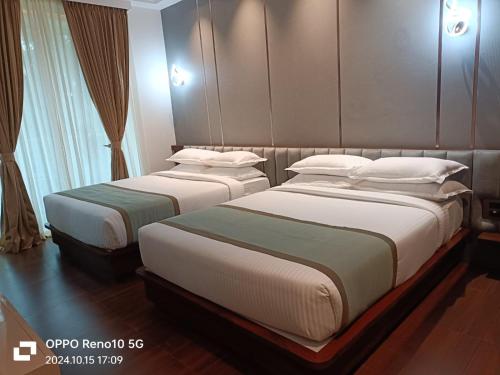 two beds in a hotel room with at SILVER CLOUD in Nandigunda