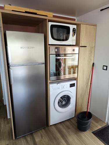 La cuisine est équipée d'un réfrigérateur, d'un four micro-ondes et d'un lave-linge. dans l'établissement MH 805 Camping Bois Dormant, à Saint-Jean-de-Monts
