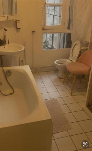 une salle de bain avec une baignoire, des toilettes et un lavabo dans l'établissement studio grand2, à Paris