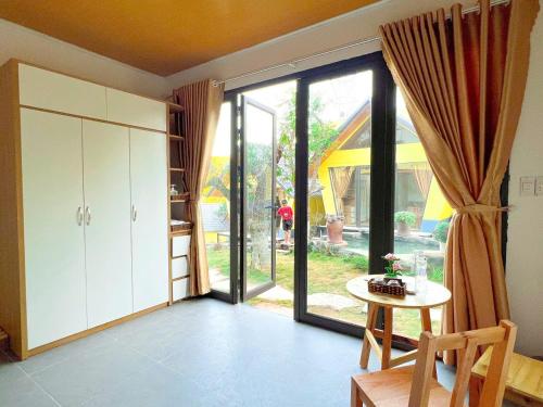a living room with a large sliding glass door at Linh Anh Homestay MC - by BAY LUXURY in Mộc Châu