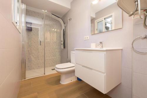 a white bathroom with a toilet and a shower at Flamenco Soul in Chiclana de la Frontera