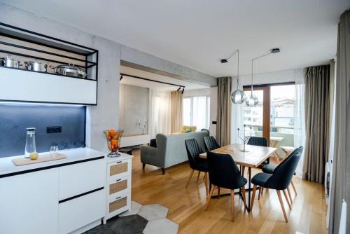 Una cocina y una sala de estar con mesa y sillas. en Luxury and Cozy Apartment with lots of Sun, en Burgas