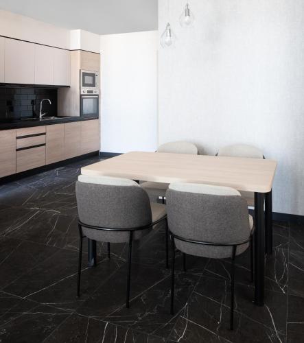 a kitchen with a table and four chairs at Park Inn by Radisson Hotel & Apartments Kuwait in Kuwait