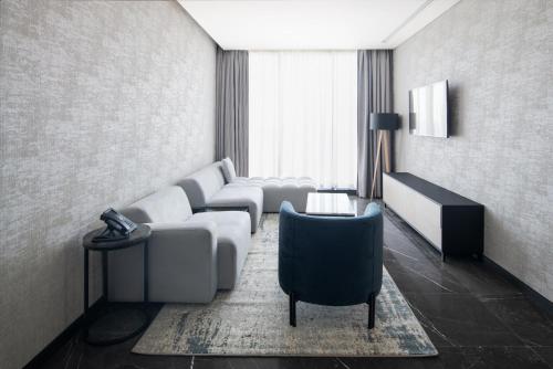 a living room with a couch and a chair at Park Inn by Radisson Hotel & Apartments Kuwait in Kuwait