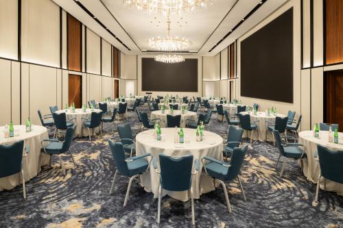 a conference room with tables and chairs and a projection screen at Park Inn by Radisson Hotel & Apartments Kuwait in Kuwait