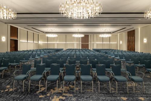 a large room with rows of chairs and chandeliers at Park Inn by Radisson Hotel & Apartments Kuwait in Kuwait