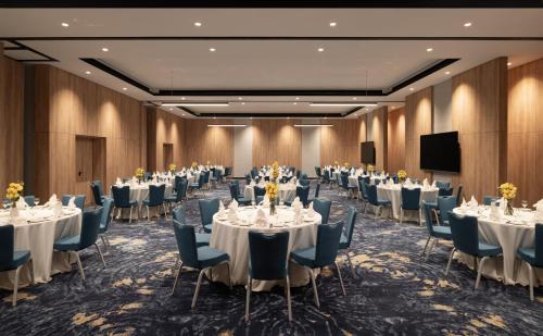 a conference room with tables and chairs and a flat screen tv at Park Inn by Radisson Hotel & Apartments Kuwait in Kuwait