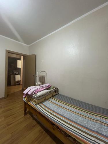 a bed sitting in a room next to a wall at Fully furnished, 1-bedroom apartment in Ulaanbaatar