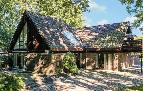 a brick house with a shingled roof at Amazing Home In Asperup in Asperup