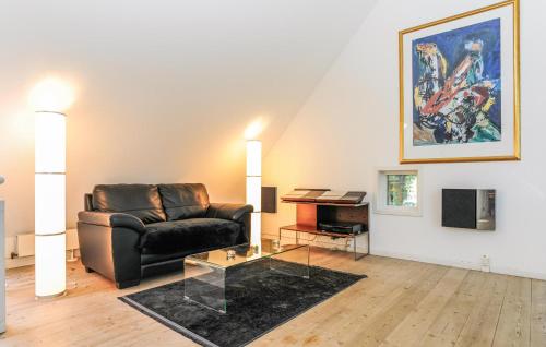 a living room with a leather chair and a table at Amazing Home In Asperup in Asperup