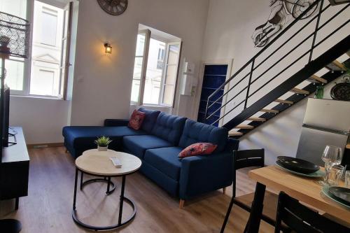 - un salon avec un canapé bleu et un escalier dans l'établissement Le loft du théâtre, à Montélimar