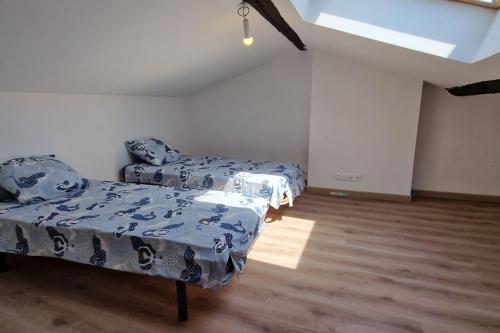 Cette chambre comprend 2 lits avec des draps bleus et blancs. dans l'établissement Le loft du théâtre, à Montélimar