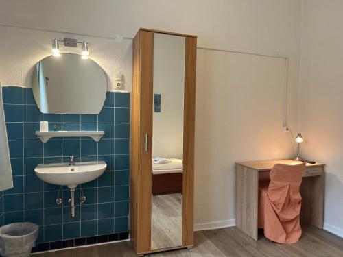 a bathroom with a sink and a mirror at Hotel Haus Schwan Köln in Cologne