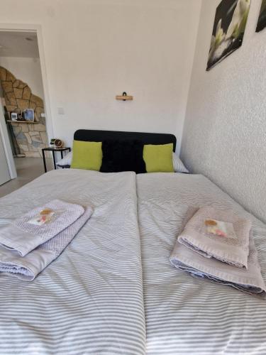 a white bed with two towels on top of it at FewoSaric Apartment Marlon in Vir