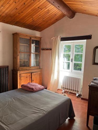 une chambre avec un lit et une fenêtre dans l'établissement Relai de randonnées pédestres, cévenoles, bassin en eau de source, randonnées d'ânes abreuvoir et enclos, à Monoblet