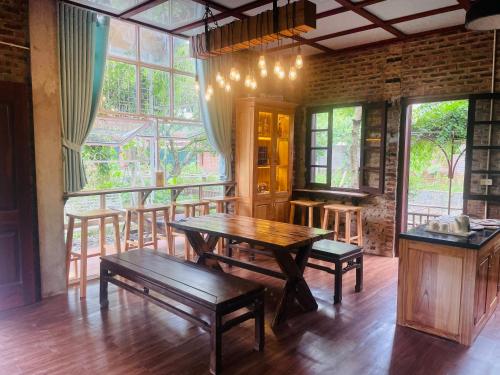 a dining room with a wooden table and benches at Morning Calm Garden villa - Ninh binh in La Phù
