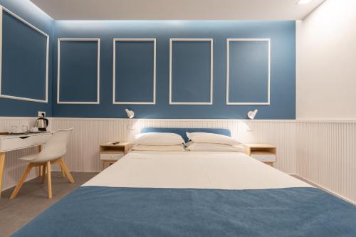 a bedroom with a large bed and blue walls at Toledo Mill Relais - By Pera Rooms Collection in Naples