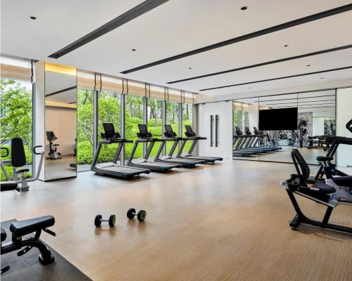 a gym with a lot of treadmills and chairs at DoubleTree by Hilton Jiangxi Fuzhou in Fuzhou