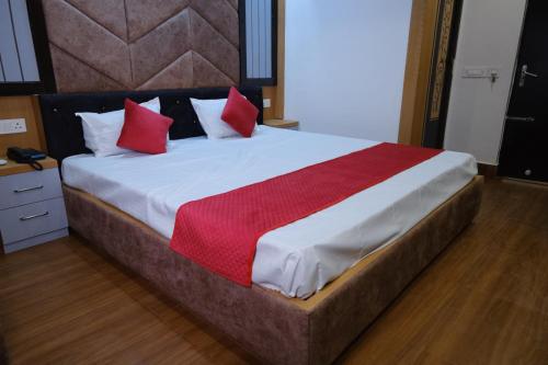 a bedroom with a large bed with red pillows at Hotel Golden Continental in Deoghar