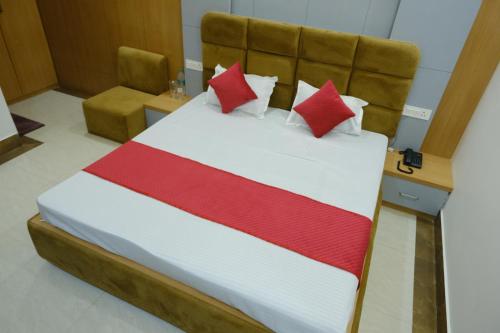 a bed with red and white sheets and pillows at Hotel Golden Continental in Deoghar
